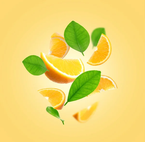 Saftiga Apelsinskivor Och Gröna Blad Flyger Blek Gyllene Bakgrund — Stockfoto