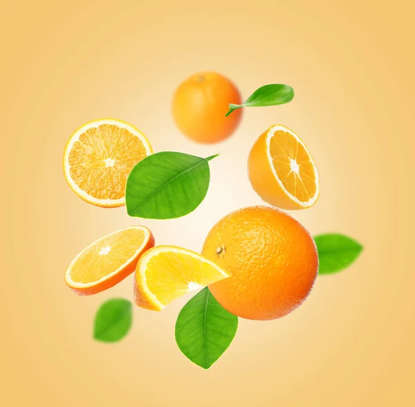 Skär Och Hela Apelsiner Med Gröna Blad Flyger Blek Orange — Stockfoto