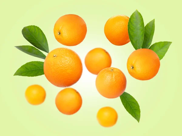 Naranjas Maduras Con Hojas Volando Sobre Fondo Verde Pálido —  Fotos de Stock