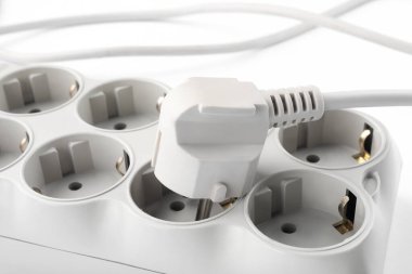 Beyaz arka planda güç şeridi, yakın plan. Elektrikçi ekipmanı.