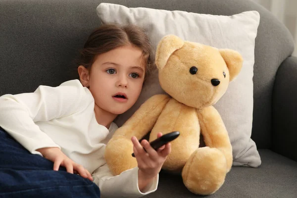 Маленька Дівчинка Іграшковим Ведмедем Змінює Телевізійні Канали Допомогою Пульта Дистанційного — стокове фото