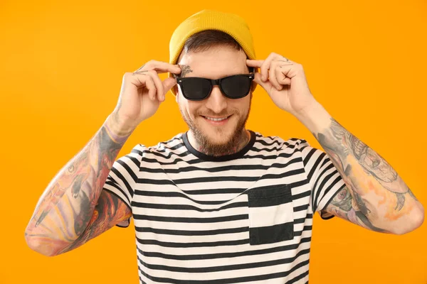 stock image Handsome hipster man wearing stylish sunglasses on orange background