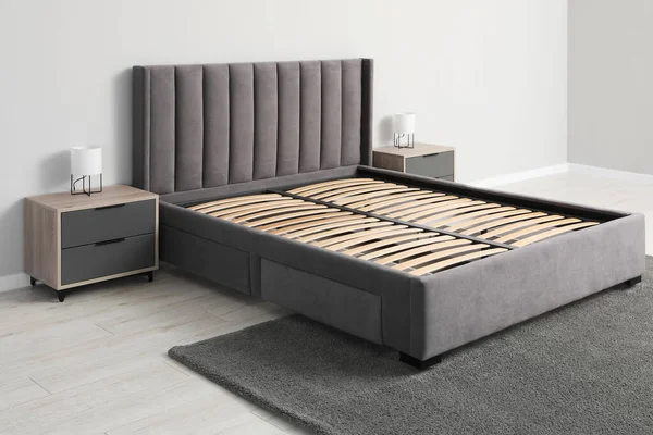 Comfortable bed with storage space for bedding under slatted base in room