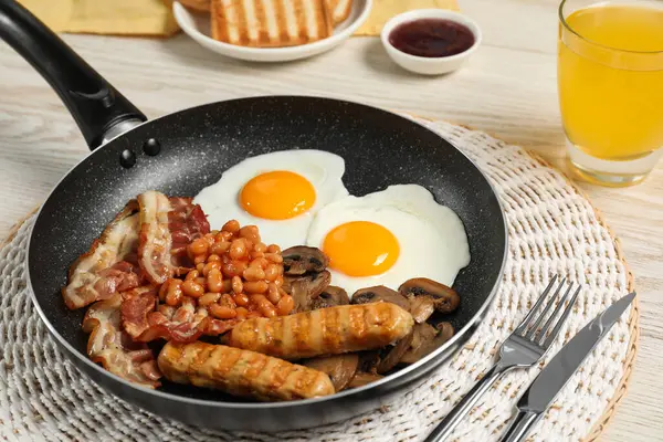 白いテーブルの上で調理された伝統的な英語の朝食とフライパンを揚げ クローズアップ — ストック写真