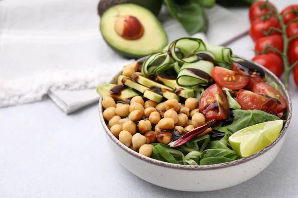 stock image Delicious salad with chickpeas, vegetables and balsamic vinegar on white table, closeup. Space for text