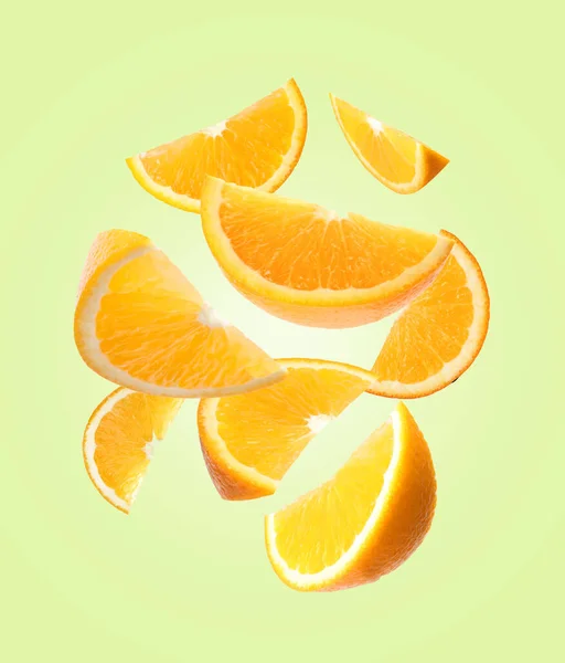 Juicy Orange Slices Flying Pale Green Background — Stock Photo, Image