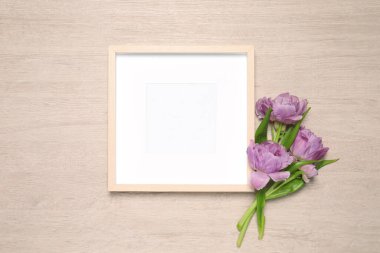 Boş fotoğraf çerçevesi ve ahşap arka planda güzel lale çiçekleri. Tasarım için model