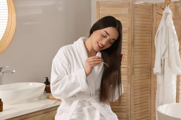 Happy Young Woman Applying Essential Oil Hair Bathroom — Stock Photo, Image