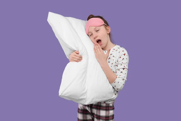 紫の背景に睡眠マスクと枕のあくびをしている女の子 不眠症の問題 — ストック写真