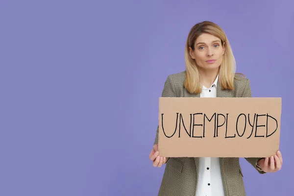 Confused Woman Holding Sign Word Unemployed Violet Background Space Text — Stock Photo, Image