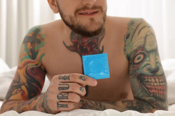 Muž Drží Kondom Posteli Doma Detailní Záběr — Stock fotografie