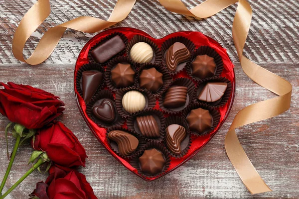 Caixa Forma Coração Com Deliciosos Doces Chocolate Rosas Fita Mesa — Fotografia de Stock