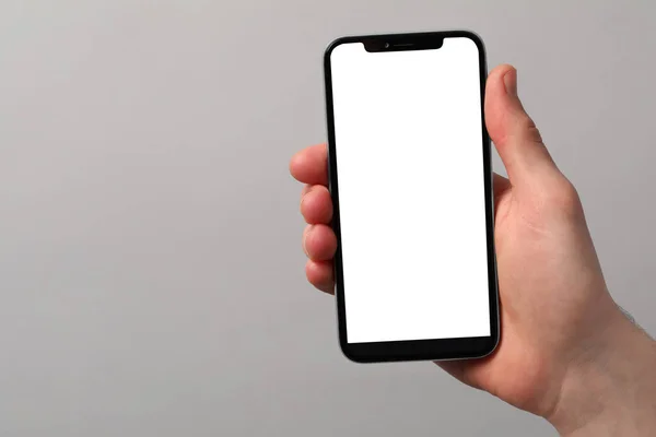 Man Håller Smartphone Med Tom Skärm Ljusgrå Bakgrund Närbild Mockup — Stockfoto