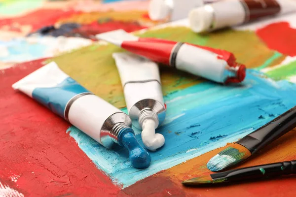 Tubos Tintas Óleo Coloridas Pincéis Sobre Tela Com Pintura Abstrata — Fotografia de Stock