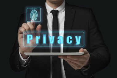Gizlilik politikası. İşadamı siyah arkaplana karşı tableti tutarken sanal ekranda gizlilik özelliğini etkinleştiriyor, kapat
