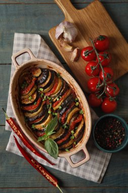 Lezzetli ratatouille ve ahşap masadaki malzemeler.