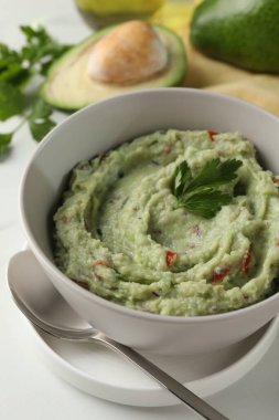 Lezzetli guacamole beyaz masada servis edilir, yakın plan.