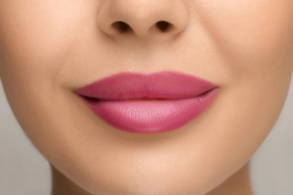 明るい背景にピンクの口紅を持つ女性 クローズアップ — ストック写真