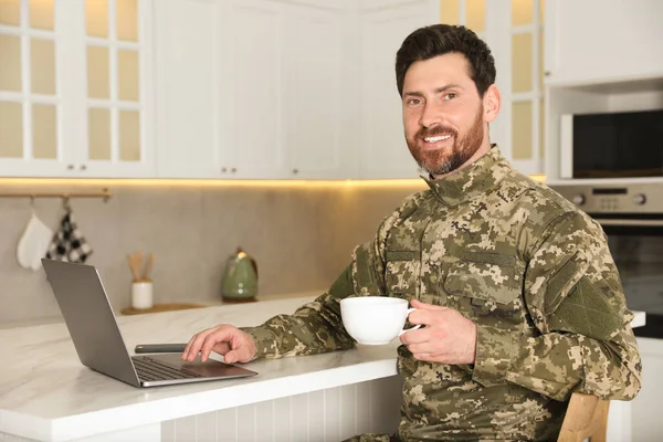 Ευτυχισμένος Στρατιώτης Φλιτζάνι Ποτό Χρησιμοποιώντας Φορητό Υπολογιστή Λευκό Μαρμάρινο Τραπέζι — Φωτογραφία Αρχείου