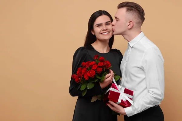 Härligt Par Med Presentask Och Bukett Röda Rosor Beige Bakgrund — Stockfoto