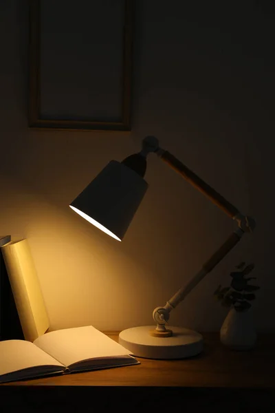 Stilvolle Moderne Schreibtischlampe Bücher Und Pflanzen Auf Holztisch Dunklen Raum — Stockfoto