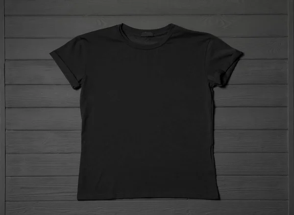 灰色木制桌子上的时髦黑色T恤 顶部视图 — 图库照片