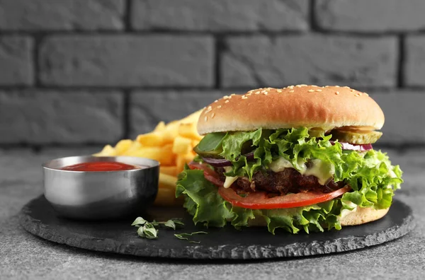 Pyszny Burger Pasztetem Wołowym Sosem Pomidorowym Frytkami Szarym Stole — Zdjęcie stockowe
