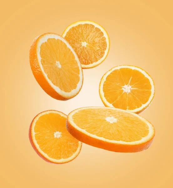 Succosa Fette Arancia Che Volano Sfondo Arancione Chiaro — Foto Stock