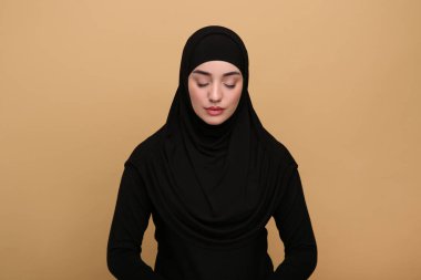 Bej arka planda tesettürlü Müslüman kadın portresi