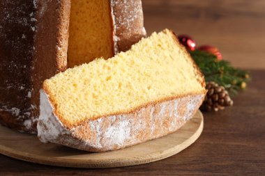 Pudra şekerli nefis Pandoro keki ve ahşap masa üzerindeki Noel süsü, yakın plan. Geleneksel İtalyan pastası