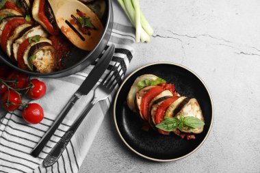 Lezzetli ratatouille, açık gri masada fesleğenle servis edilir. Metin için boşluk