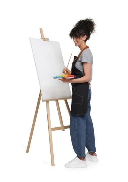 画架上的年轻女子用帆布在白色背景下绘画 — 图库照片