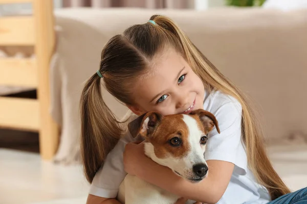 かわいい女の子が家で犬を抱きかかえている 愛らしいペット — ストック写真