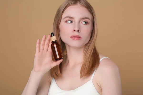 Vacker Ung Kvinna Med Flaska Eterisk Olja Brun Bakgrund — Stockfoto