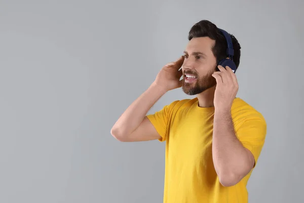 Ευτυχισμένος Άνθρωπος Ακούει Μουσική Ακουστικά Ανοιχτό Γκρι Φόντο Χώρος Για — Φωτογραφία Αρχείου