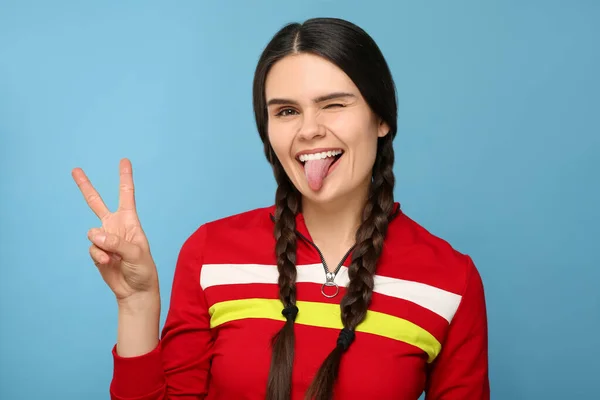 Dilini Açık Mavi Arka Planda Gösteren Mutlu Genç Bir Kadın — Stok fotoğraf