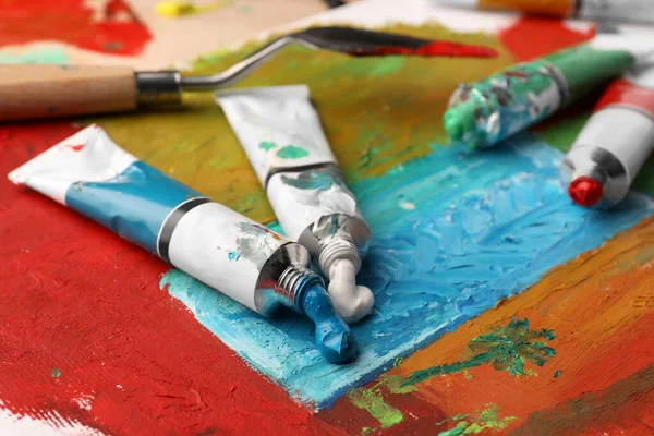 Tubos Tintas Óleo Coloridas Espátula Sobre Tela Com Pintura Abstrata — Fotografia de Stock