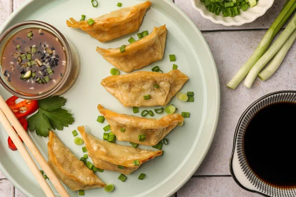 Lezzetli gyoza (Asya hamur tatlısı) hafif fayanslı masada servis edilir, düz yatar.