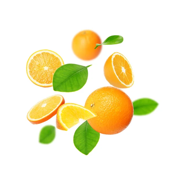 Snittade Och Hela Apelsiner Med Gröna Blad Flyger Vit Bakgrund — Stockfoto