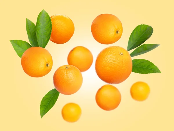 Reife Orangen Mit Grünen Blättern Auf Hellgoldenem Hintergrund — Stockfoto