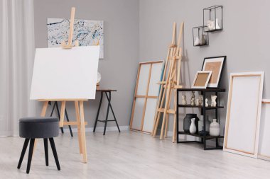 Resim sehpaları, tuvaller ve boya malzemeleriyle sanatçı stüdyosu.