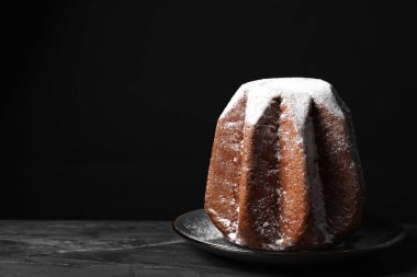 Koyu masada pudra şekerle süslenmiş leziz Pandoro pastası, mesaj için yer var. Geleneksel İtalyan pastası