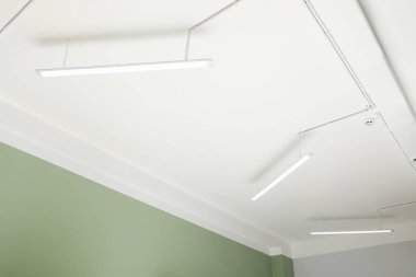 White ceiling with modern lighting in room, low angle view