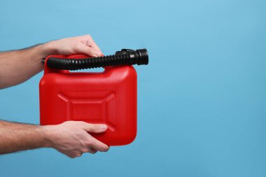 Açık mavi arka planda kırmızı kutu tutan adam, yakın plan. Metin için boşluk