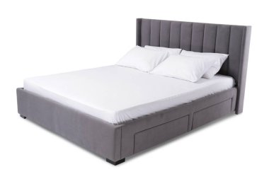 Beyaz arka planda çarşafları olan rahat gri yatak.