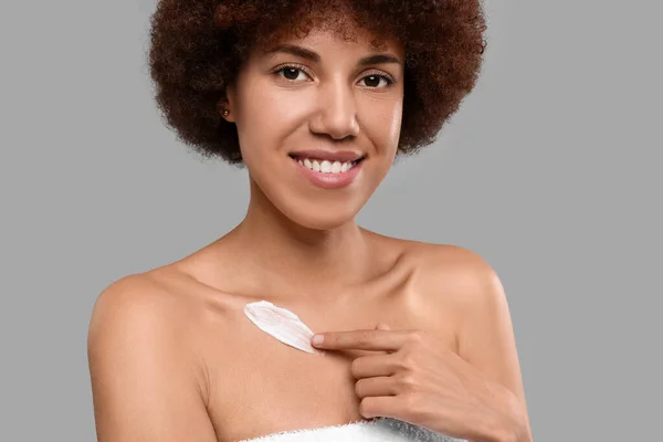 Mooie Jonge Vrouw Aanbrengen Crème Lichaam Grijze Achtergrond — Stockfoto