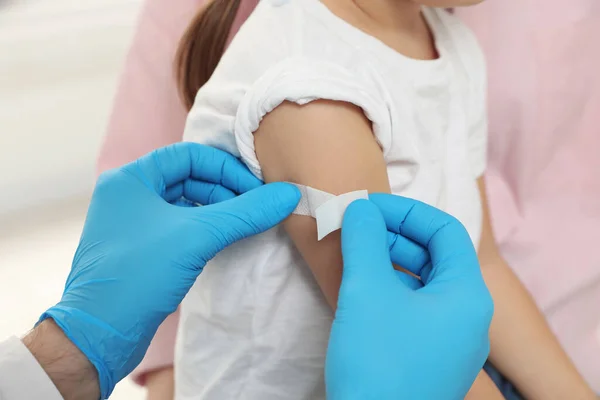 儿童肝炎疫苗接种 妈妈和她的女儿 医生把药膏贴在小女孩的胳膊上 — 图库照片
