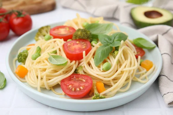 stock image Plate of delicious pasta primavera and ingredients on white table, closeup