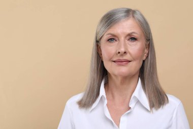 Bej arka planda güzel bir son sınıf kadınının portresi. Metin için boşluk