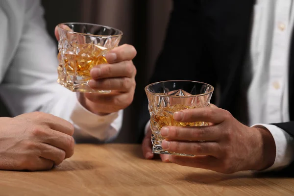 木製のテーブルの中にウイスキーのグラスを持つ男性 クローズアップ — ストック写真
